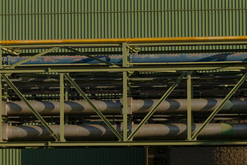 A large collection of pipes is carefully stacked in a vertical arrangement on top of one another,...