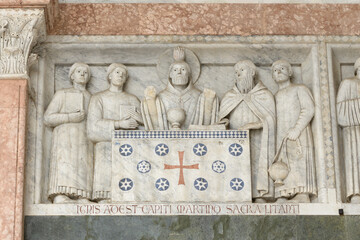 Relief of Saint Martin celebrating Mass with clergy on the facade of San Martino Cathedral, Lucca,...
