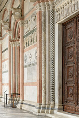 Romanesque portal with marble columns and carved arch at San Martino Cathedral, Lucca, Italy.