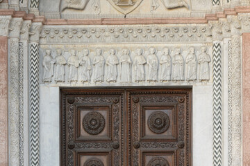 Main portal of San Martino Cathedral in Lucca, Italy, with Romanesque reliefs, polychrome marble...