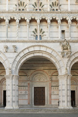 Main facade of San Martino Cathedral in Lucca, Italy, with Romanesque arcades and sculpture of...