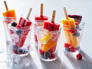 Refreshing Fruit Popsicles Served in Glasses with Berries and Ice Cubes