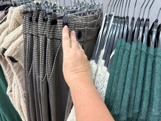 customer browsing clothes in store, checking fabric, Retail therapy, finding size, affordable...