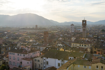 View from Torre Guinigi over rooftops of Lucca, Tuscany, Italy, showing Torre delle Ore and bell...