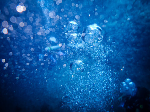 水中に広がる気泡と青い光
