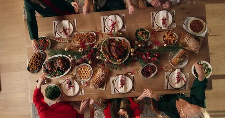 Holding hands, praying and family at christmas dinner in home for festive celebration, event or party. Food, top view and people in dining room with prayer for meal, feast or supper for xmas in house - Powered by Adobe