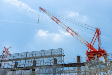 クライミングクレーンと建設中のビル。建設現場のイメージ