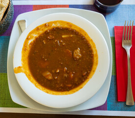 Red lentil soup with carrots and pork pieces is traditional European hot dish for lunch or dinner..