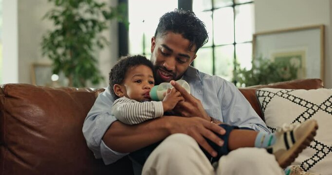 Love, bottle and father with baby in home for feeding, bonding or afternoon formula on couch. Relax, care and dad with child drinking milk for growth, development or nutrition in living room in house