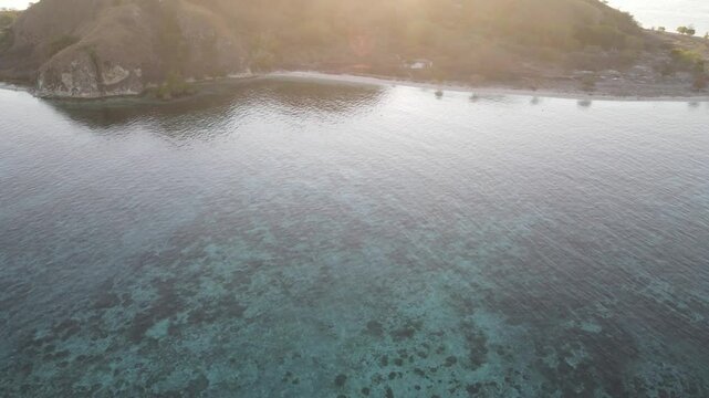 Aerial landscape view of Kanawa Island beach with long bridge dock surrounded by turquoise ocean.