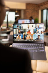 African american individual holding laptop with screen displaying live webinar of diverse business...
