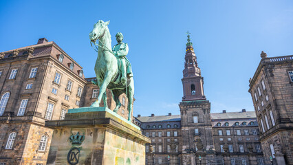 The equestrian statue of Christian IX stands majestically outside Christiansborg Palace, under a...