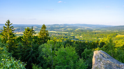 At dusk, the Popov Cliffs in the Lusatian Mountains offer a breathtaking view. Surrounding forested hills and valleys create a tranquil atmosphere perfect for evening exploration.