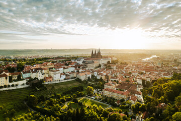 Golden sunlight bathes Prague Castle and the surrounding city as day breaks. The colorful rooftops...