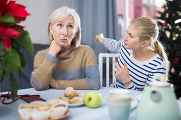 Adult daughter, who came to visit before Christmas, quarrels with her mature mother, trying to...
