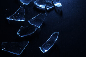 Broken Glass Shards on Dark Surface with Cold Lighting