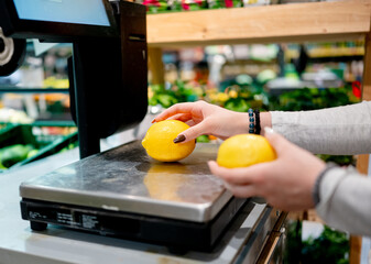 Girl Weighing Lemons In Supermarket