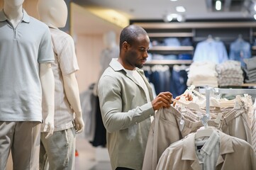 Stylish man choosing clothes in fashion store