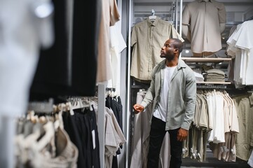Stylish man shopping for clothes in mall