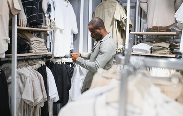 Stylish man choosing clothes in fashion store