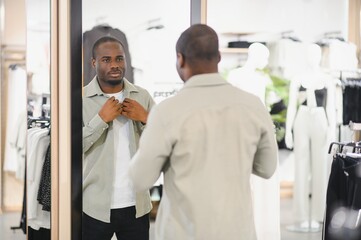 Customer trying clothes in dressing room mirror at fashion store