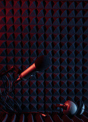 Сkose-up view of microphones positioned against a textured dark soundproof wall in a recording...