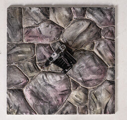 A vintage typewriter is placed on a creatively designed stone pattern surface. The textured stones...