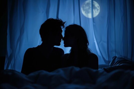 Romantic couple sharing a kiss in bed with the moon in the background