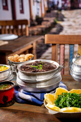 Typical Brazilian dish feijoada based on black beans and pork with crakloing, rice and orange.