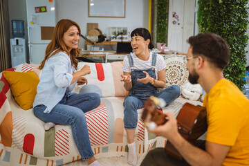 Group of multicultural people have fun, enjoy the sounds of the guitar