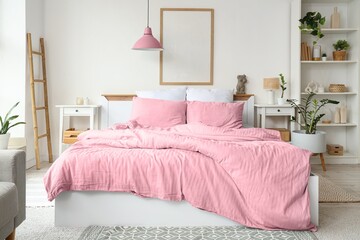 Interior of light bedroom with cozy bed, shelving unit and houseplants