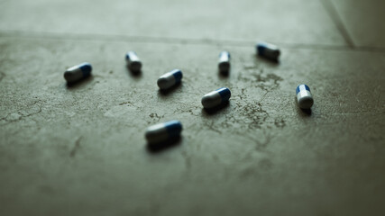 Close-Up of Medicine Capsules Scattered on Tiled Floor


