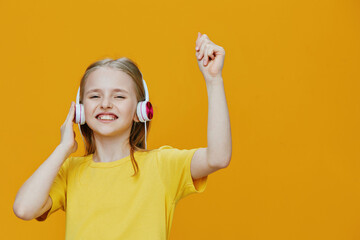 A joyful young girl in a bright yellow shirt and headphones dancing happily against a vibrant...