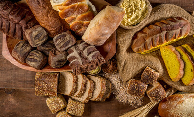 assortment of baked bread on wooden table background. top view