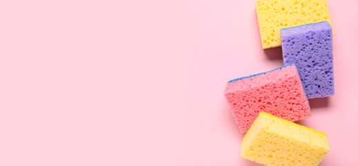 Cleaning sponges on pink background with space for text