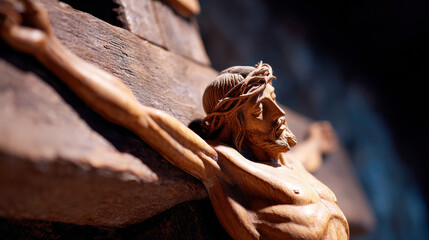Wooden crucifix close up of Jesus Christ figure with crown of thorns detailed carving dramatic lighting religious symbol Christian faith sorrowful expression textured wood background