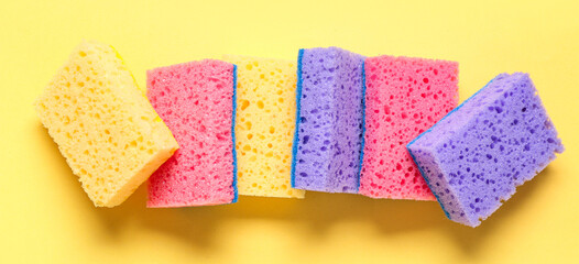 Many cleaning sponges on yellow background, top view