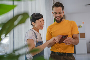 japanese woman and caucasian man friends or couple use mobile phone