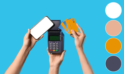 Hands holding payment terminal with credit cards and mobile phone on blue background. Different...