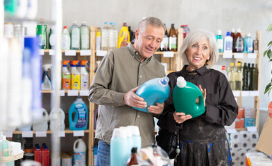 Senior spouses buyer select and studies label, read composition of liquid detergent. Client examine...