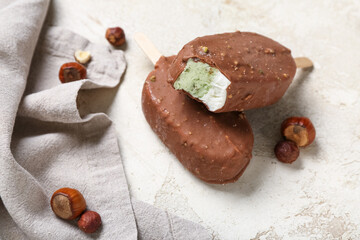 Tasty chocolate covered ice cream on light background
