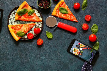Plate with tasty pizza margarita  and phone on black grunge background