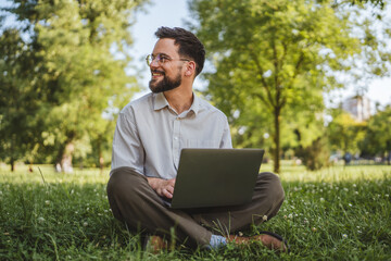 businessman sit on grass in nature and use laptop for work or leisure