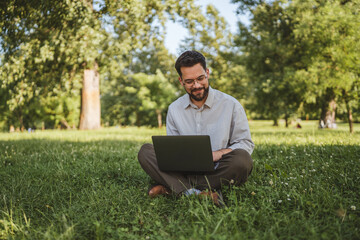 businessman sit on grass in nature and use laptop for work or leisure