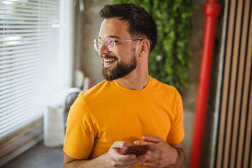 cheerful adult man use mobile phone in the kitchen