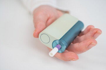 Woman holding electronic cigarette on white background. Tobacco heating systems.