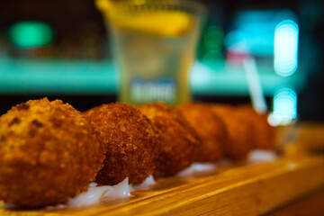 Delicious fried appetizers arranged on a wooden serving board, ready to be enjoyed.