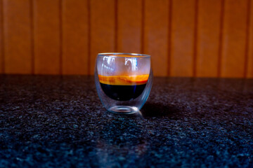 This stylish shot showcases a double-walled glass filled with rich, layered espresso.