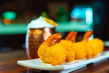 Golden tempura shrimp beautifully arranged on a white plate, ready to eat.