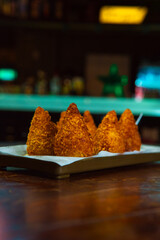 Crispy golden fried food, ideal as appetizers, beautifully arranged on a wooden table.